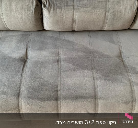 ספה אפורה עם כתמי מים לאחר ניקוי